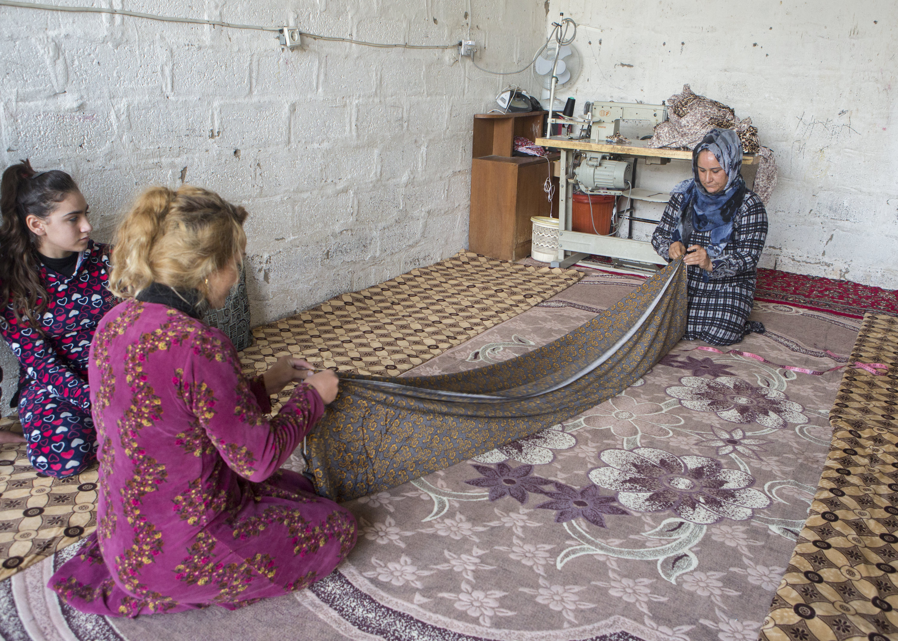 Shireen and her daughter-in-law preparing the fabric for the traditional Kurdish dress. Photo: Alison Baskerville.