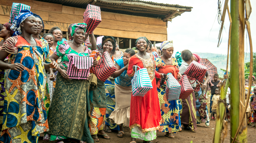 Women show off the baskets they made in vocational training