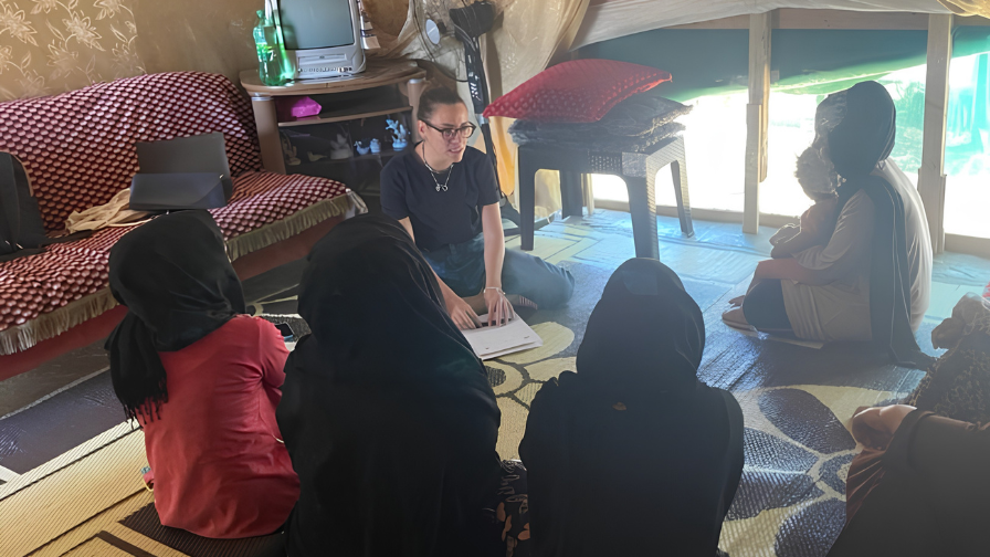 KAFA associates sat in a group with children outside