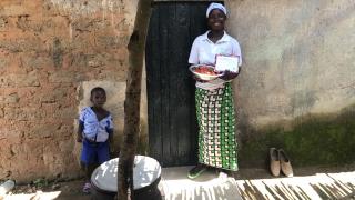 A programme participant from Nigeria holding her #MessageToMySister postcard. Photo: Women for Women International