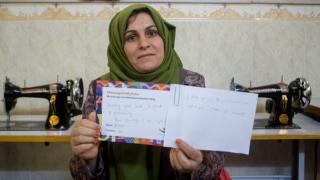 Sazgar, one of our programme participants in Iraq holding her translated #MessageToMySister from Adam in the UK. Photo: Alison Baskerville