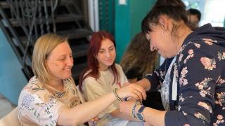 Women refugees from Ukraine sharing bracelets created in art therapy with our partners at Bereginia - Mariupol’s Women’s Association. Photo credit: Kateryna