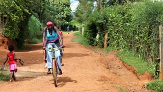 Alphonsine rides her bicycle through her neighborhood. Photo: Women for Women International