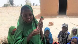 Amina, pupil of Rudugungu Community, is happy to be learning with her friends at her new school. Photo Credit: Women for Women International