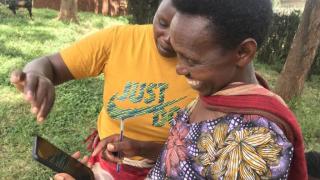 Programme participants showing excitement to be testing the DreamSave app for their savings accounts in Rwanda. Photo: Women for Women International