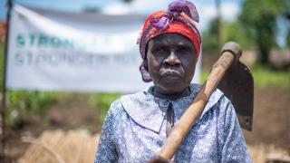 Kila James from South Sudan standing in her farm. Credit: Charles Atiki Lomodong