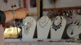 Ferhana handling jewellery in her shop. Photo: Women for Women International