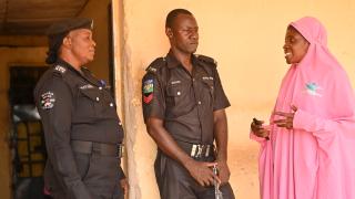 Hadiza speaking to two Police officers, including a female officer who was assigned to the community post thanks to Hadiza and her Change Agent group’s advocacy efforts. This will help protect women in Hadiza’s community from cases of gender-based violence. Photo: Women for Women International  