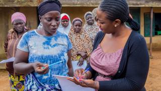 Staff member speaking to a woman at enrolment day in Nigeria. Photo: Monilekan