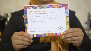 Programme participant in Iraq holds up a message she received from a supporter in London.