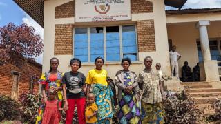 Ida Mukungilwa stands outside her office alongside some women whom she is supporting. Photo: Women for Women International