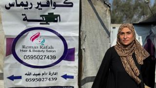 In the midst of conflict and displacement, Tahreer has reopened her hairdressing work from her tent, doing everything she can to keep her children safe and fed. Photo credit: Women for Women International.