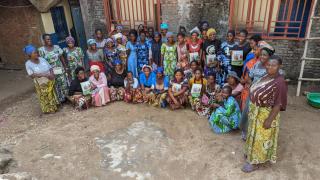 Women lined up in formation for group photo while standing outside a newly opened training centre in DRC