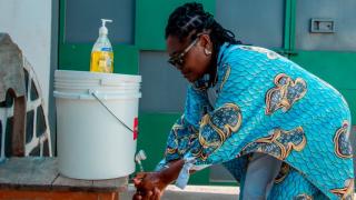 Vianney Dong washing her hands at one of the newly installed handwashing stations. Photo credit: Alexi Daudi