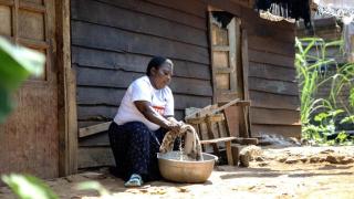 Faida washes clothes in front of her house. Photo: Patrick Luhiriri