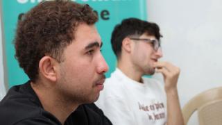 Two young men sat and paying attention to a lecture