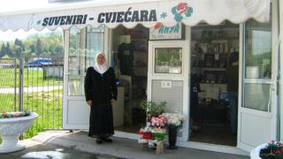 Fazila standing outside her flower shop at the Srebrenica-Potocari Memorial Centre