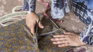 Woman cutting fabric to sew clothes. Photo: Alison Baskerville