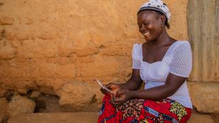 Faith, a Women for Women International participant from Nigeria reading a letter from her Stand With Her sister. Photo: Monilekan