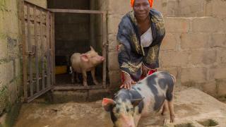 Nanbam with her pigs she purchased using her stipend. Photo: Monilekan