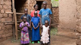 Grace stands with her children outside of their home. Photo: Hazel Thompson