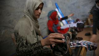 A programme participant prepares a sewing machine for tailoring work. Photo credit: Women for Women International.