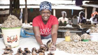Alice, a programme participant from Yei in South Sudan, sells fish from her market stall. Credit: Charles Atiki Lomodong