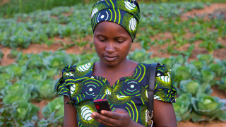 A programme graduate using mobile money to pay her bills