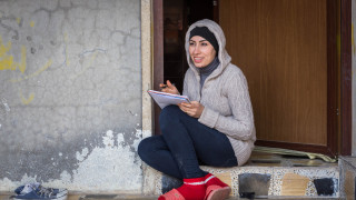 Eman Mohammed Jumaa writes her sponsor a letter at her home in Daratu, Iraq