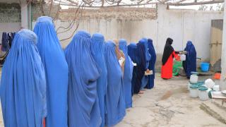Women in Burqas queue.