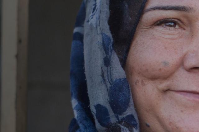 Shireen, a Syrian refugee in Iraq, smiling and looking to the right