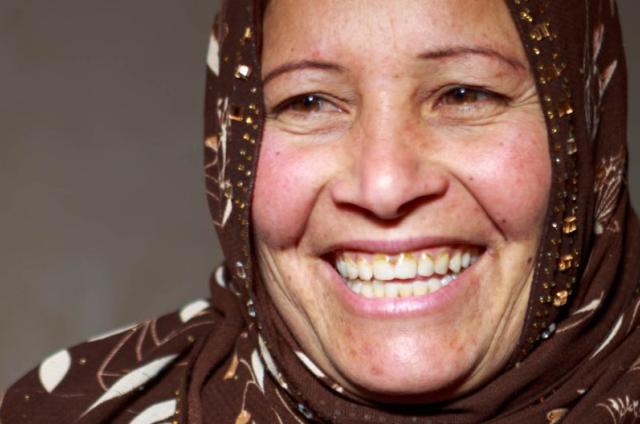 Facial close up of women smiling on a dark background