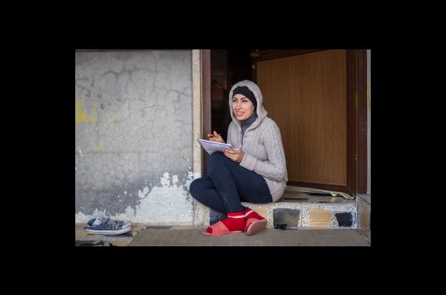 Eman Mohammed Jumaa writes her sponsor a letter at her home in Daratu, Iraq