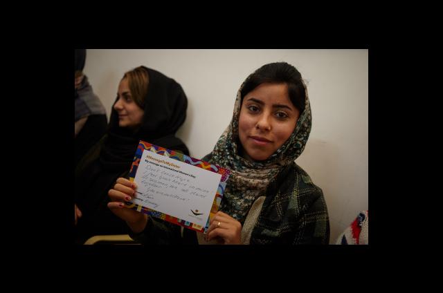 One of our programme participants in Iraq holding her #MessageToMySister from a supporter in Norway. Photo: Women for Women International 