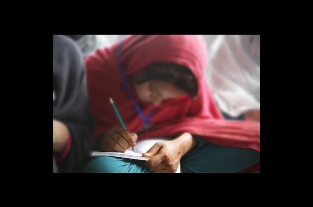 Women for Women International-Afghanistan participant practices writing numbers in numeracy class