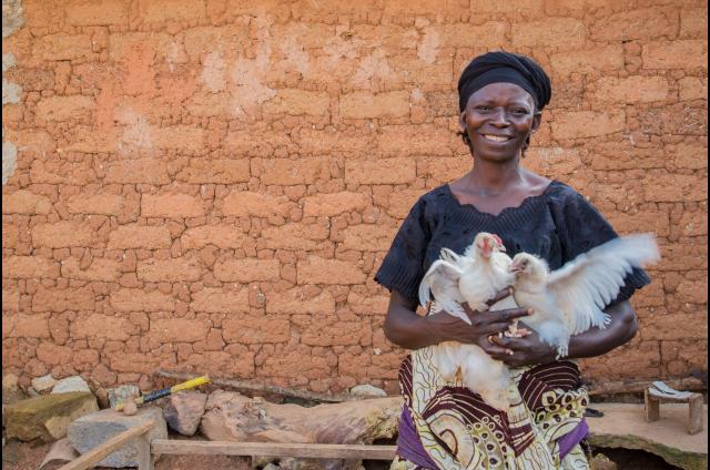 Programme participant in Nigeria holding hens. 